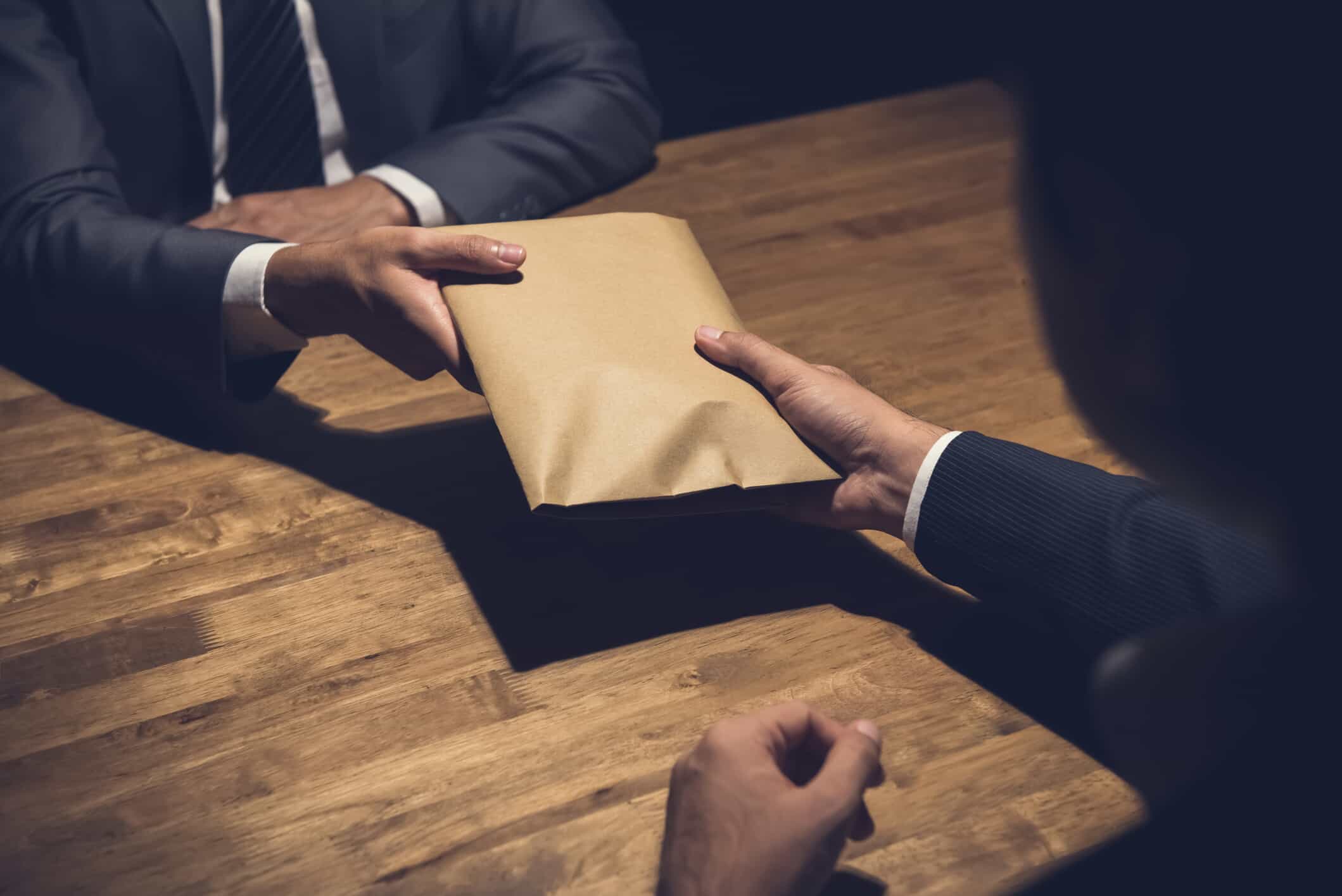 Two man in suits handing over a package